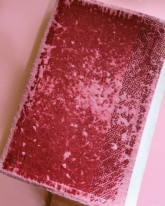 Bíblia com capa de tecido vinho puída e esfarelada nas bordas
