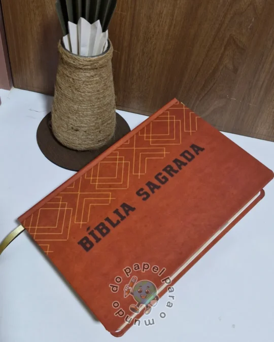 Bíblia reformada com capa caramelo, padrão geométrico e a inscrição Bíblia Sagrada em dourado