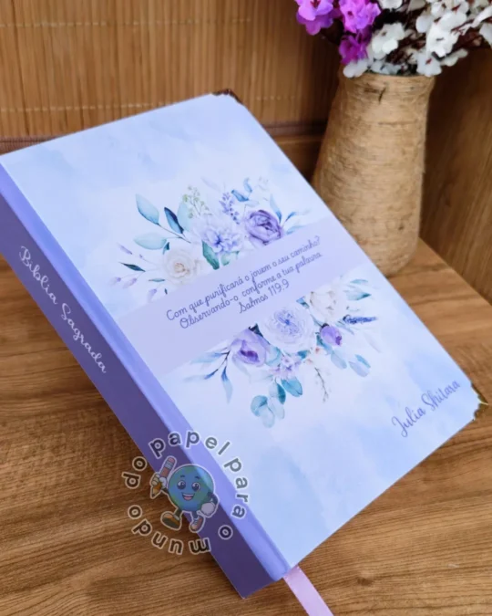 Bíblia reformada com capa lilás, arranjo de flores em aquarela, versículo impresso e nome da cliente