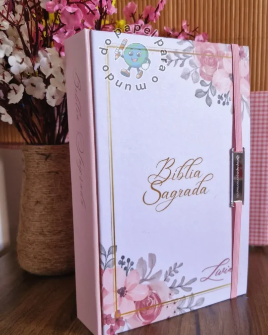 Bíblia reformada com capa dura rosa claro, arte floral e o nome da cliente aplicado em dourado, com fecho lateral
